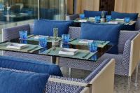 マスカットにあるW Muscatの青い椅子と青いグラスが置かれたテーブル