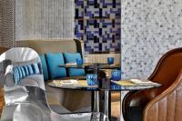 マスカットにあるW Muscatのレストランの青いグラスが置かれた2つのテーブル