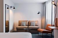 a hotel room with a couch and a chair at Moxy Paris Bastille in Paris