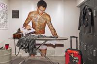 a man with tattoos on his torso standing next to a table at Moxy Paris Bastille in Paris