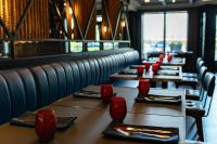 弗雷德里克顿弗雷德里克顿三角洲万豪酒店的餐厅里一排桌子，桌子旁放着红色玻璃杯