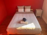a bedroom with a bed with a red wall at Bogota - maison familiale - tramway - Canal+&#47;sport in Le Mans