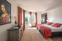 a bedroom with a bed and a painting on the wall at Surplage Hotel Cavalière in Le Lavandou