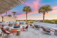 un patio con sillas, mesas y palmeras en The Ritz-Carlton, Amelia Island, en Fernandina Beach