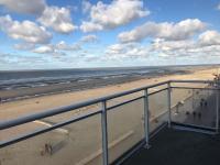 a view of the beach from a balcony at Golf 0401 seafront apartment with balcony in De Haan