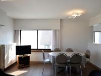 a dining room with a table and chairs and a tv at Golf 0401 seafront apartment with balcony in De Haan