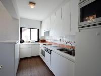 a white kitchen with white cabinets and a sink at Golf 0401 seafront apartment with balcony in De Haan