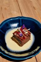 Un trozo de pastel de chocolate en un plato azul en Domaine Pozzo di Mastri hôtel & spa, en Figari