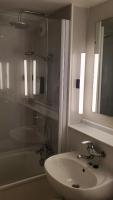 a bathroom with a sink and a mirror and a tub at KYRIAD HONFLEUR - La Riviere Saint Sauveur in Honfleur