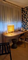 a desk with a lamp on it in front of a window at KYRIAD HONFLEUR - La Riviere Saint Sauveur in Honfleur
