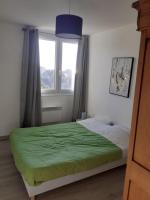 a bedroom with a green bed and a window at Appart calme à la mer in Équihen-Plage