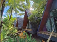 a house with a balcony and some trees and plants at Homestay Nam Hàm Luông in Ben Tre