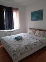 a bedroom with a bed with a comforter on it at Apartment Ken in Surčin