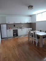 a kitchen with white cabinets and a table and chairs at Apartment Ken in Surčin