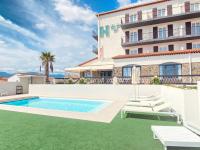 a villa with a swimming pool in front of a building at Hôtel Le Belvedere in Saint-Cyprien