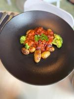 Un plato de comida con brócoli y salsa. en LyvInn Hotel Frankfurt, en Frankfurt