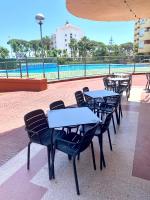 eine Reihe von Tischen und Stühlen neben einem Pool in der Unterkunft New! Seaview-Vistas al Mar con Piscina en La Pineda in La Pineda