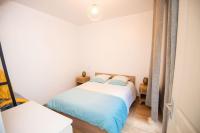 a bedroom with a bed with blue and white sheets at MAISON DIVISÉE EN 2 APPARTEMENTS POUR 8 PERSONNES in Vermenton