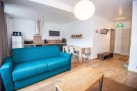 a living room with a blue couch and a kitchen at MAISON DIVISÉE EN 2 APPARTEMENTS POUR 8 PERSONNES in Vermenton