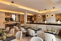 Un restaurante con mesas y sillas y un bar. en Hôtel Esté, en París