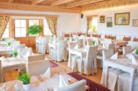 Una habitación con mesas y sillas blancas y ventanas. en Hotel Głęboczek Vine Resort& Spa, en Wielki Głęboczek