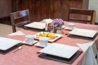 een tafel met een roze tafelkleed en een schaal met fruit bij Casa de las Flores Hotel in Oaxaca City