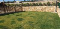 a backyard with a stone fence and a grass yard at Larah Land 4 Star Glamping Yala Lodge plus kids lodge in Šimuni
