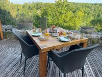 a wooden table with chairs on a deck at Domaine du Châtelard in Dirac