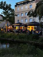 a hotel with people sitting at tables in front of it at Hotel zur Mühle in Paderborn