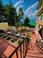 eine Terrasse mit Stühlen und Tischen auf dem Balkon in der Unterkunft Candle Wood in Bhurban