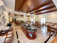 DahungLE SEMAR HOTEL KARAWACI的一家有着木质天花板、桌椅的餐厅