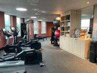 a gym with treadmills and ellipticals in a room at Moxy The Hague in The Hague