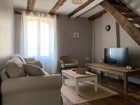 ein Wohnzimmer mit einem Sofa, einem TV und einem Tisch in der Unterkunft L&#39;Authentique maison de charme in Aubusson
