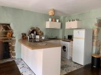 eine Küche mit einem Kühlschrank, einer Waschmaschine und einem Trockner in der Unterkunft L&#39;Authentique maison de charme in Aubusson