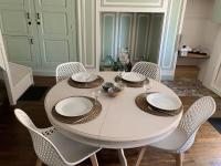 einen weißen Tisch mit Stühlen und Teller und Schüsseln darauf in der Unterkunft L&#39;Authentique maison de charme in Aubusson