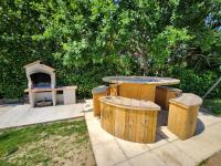 a patio with a table and a pizza oven at Le clos de lignac in Cieux