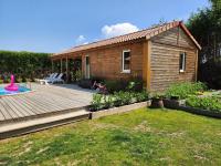 a small house with a deck and a backyard at Le clos de lignac in Cieux