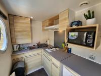 a kitchen with wooden cabinets and a microwave at Le clos de lignac in Cieux