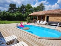 a swimming pool with a pink swan on a wooden deck at Le clos de lignac in Cieux