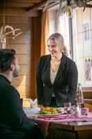 a woman sitting at a table with a plate of food at Hotel König Ludwig in Altötting