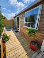 a wooden deck on a house with a patio at Le clos de lignac in Cieux