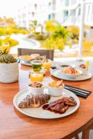 a wooden table with plates of food on it at Chogogo Dive & Beach Resort Bonaire in Kralendijk