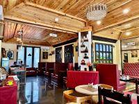 un ristorante con sedie, tavoli e lampadario a braccio di Silver Cloud Hotel a Paro