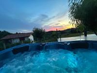 a hot tub in a yard with a sunset in the background at Chez Céline et Marc in Hasparren