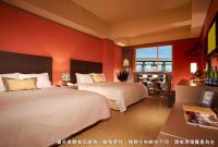 two beds in a hotel room with orange walls at Leofoo Resort Guanshi in Guanxi