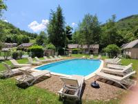Una piscina con tumbonas y un montón de en Village 17 gites, Piscine, Restaurant , 2 gites avec SPA, 3km de Conques, en Conques