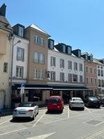 a parking lot with cars parked in front of a building at Hotel Le Postillon in Echternach
