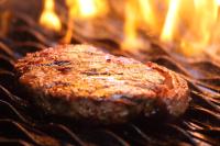 MiddelburgにあるCeltis Country Lodge & Restaurantの火のついたグリルで焼かれたハンバーガー