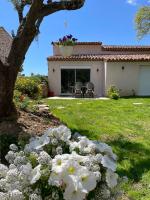 einen Hof mit weißen Blumen vor einem Haus in der Unterkunft Cottage les Marjoris Tanneron in Tanneron