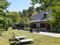 a building with a picnic table and chairs in the grass at les orchidees sauvages in Touffreville-la-Corbeline